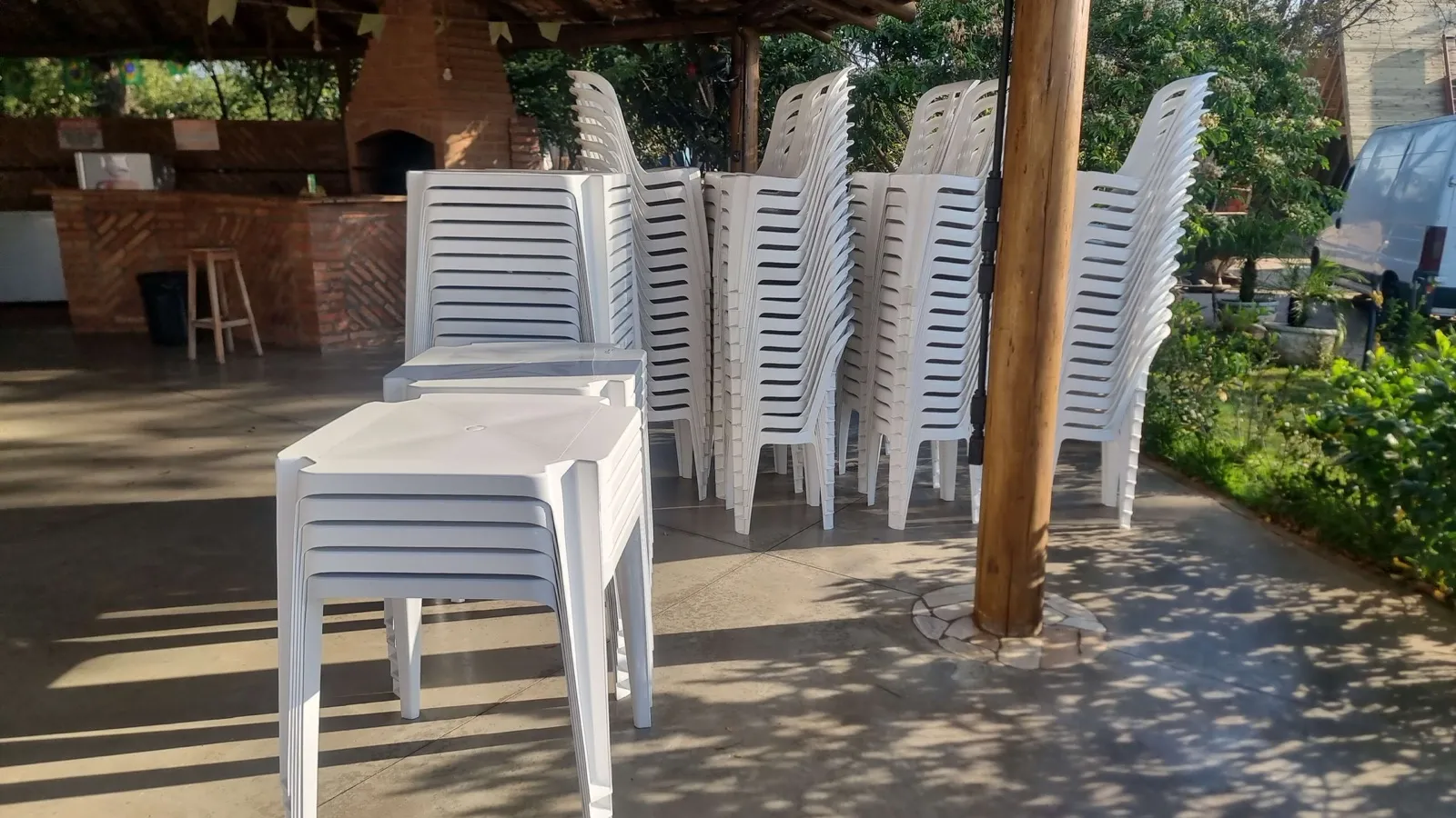 Mesas quadradas e cadeiras brancas preparadas para entrega
