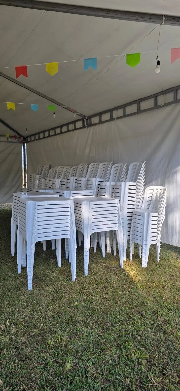 Mesas e cadeiras brancas entregues em local de evento