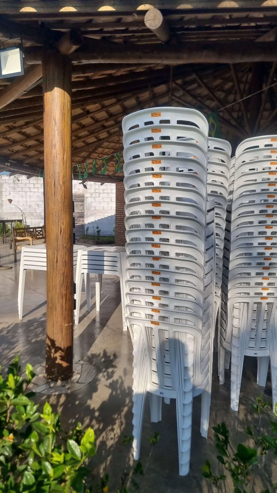 Diversas cadeiras plásticas brancas empilhadas para entrega